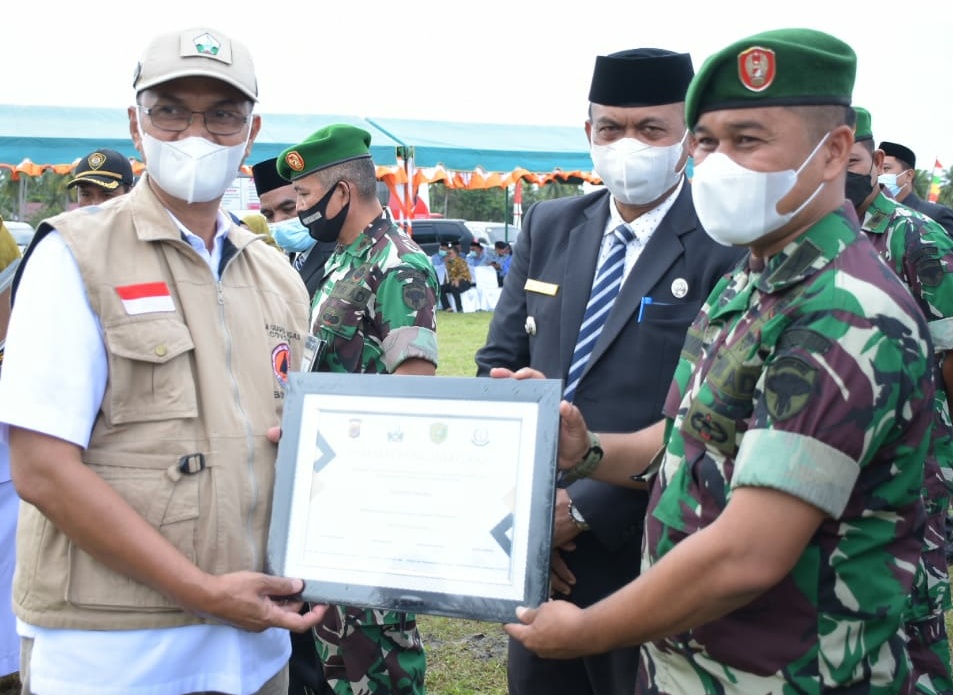 Bupati Bireuen, Dr Muzakkar A Gani SH M.Si menyerahkan penghargaan kepada Danramil 07/Jangka, Kapten Inf Syawaluddin dalam peringatan HKN ke 57 di Gampong Lingka Kuta, Kecamatan Kutablang.