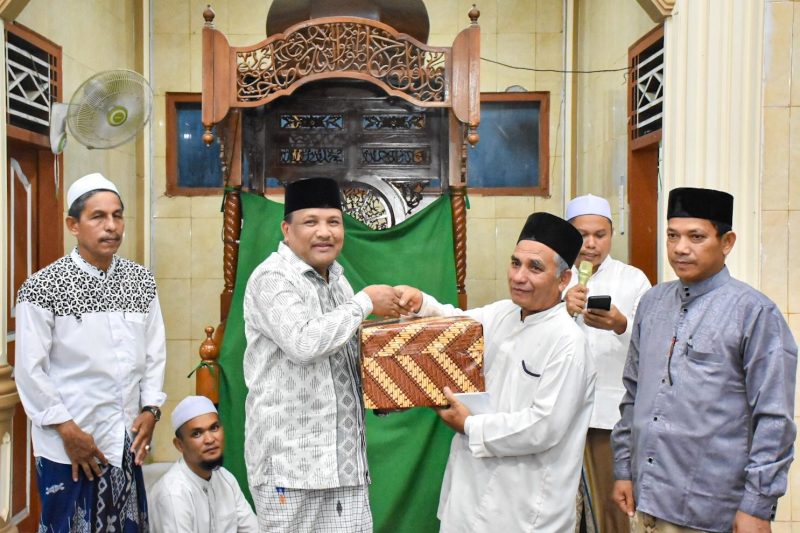Bupati Bireuen, H Mukhlis menyerahkan bantuan kepada Imuem Syik Mesjid Nurul Huda Blang Guron, Tgk M Yunus