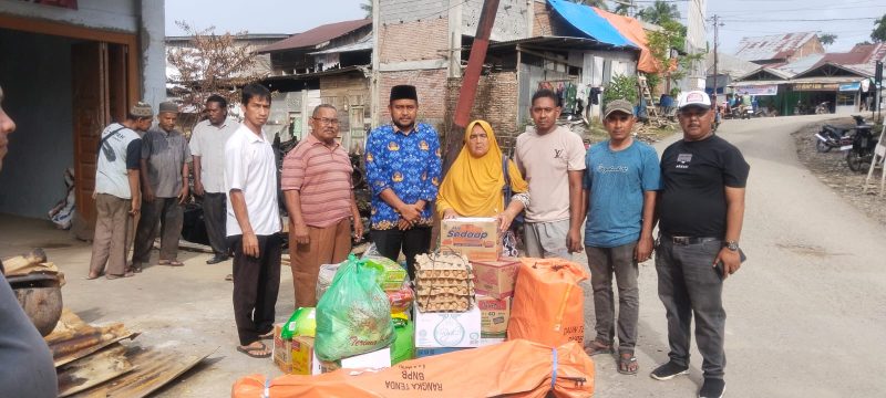 Camat Juli, Hendry Maulana menyerahkan bantuan untuk Nurjannah (jilbab kuning-red) korban kebakaran di Teupin Mane, Rabu (17/12)