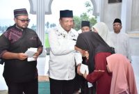 Bupati Bireuen, H Mukhlis ST menyerahkan santunan kepada anak yatim, Rabu (25/2/2027) sore di Masjid Abu Hamid, Gampong Arongan, Kecamatan Samalanga