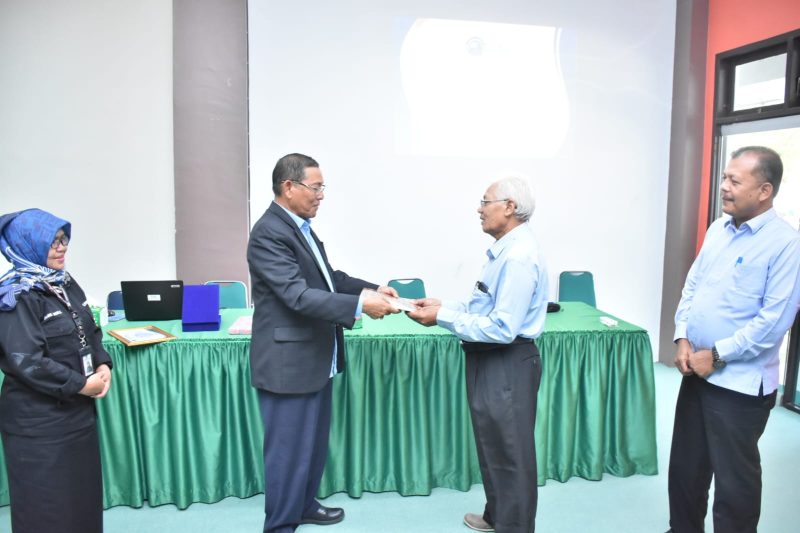 Rektor UNIKI Bireuen, Dr Zainuddin Iba SE MSi menyerahkan penghargaan dan pesangon kepada Dosen Purna Bakti Sutoyo SE MSi, di ruangan Telecoference Kampus UNIKI, Senin (2/3) pagi.