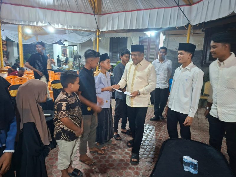 Bupati Bireuen, H Mukhlis ST sedang menyerahkan santunan kepada anak yatim, Rabu (18/3) sore.