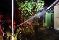 Petugas pemadam melakukan proses pendinginan rumah permanen ludes terbakar di Dusun Lam Pucok, Desa Cot Rabo Tunong, Kecamatan Peusangan, Kabupaten Bireuen, Rabu (25/3) pukul 22.00 WIB.