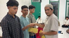 Pj Keuchik Geulanggang Baro, Ir Zairipan ST menyerahkan santunan kepada anak-anak yatim di meunasah, Senin (16/3) malam