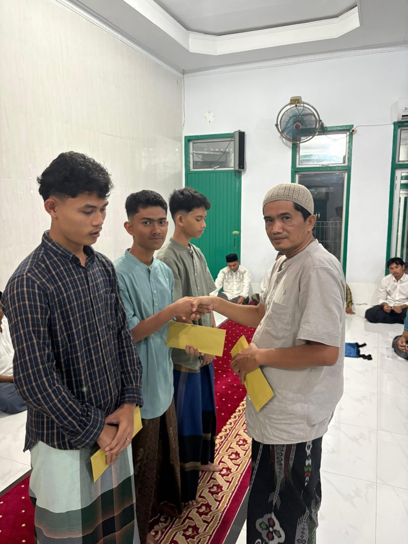 Pj Keuchik Geulanggang Baro, Ir Zairipan ST menyerahkan santunan kepada anak-anak yatim di meunasah, Senin (16/3) malam