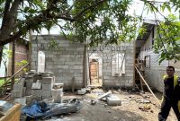 Seorang warga melintas di depan Huntap yang sedang dibangun BNPB di Kecamatan Jangka