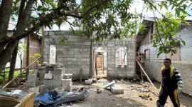 Seorang warga melintas di depan Huntap yang sedang dibangun BNPB di Kecamatan Jangka