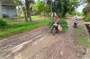 M Fadli (54) warga Gampong Paya Dua, Kecamatan Makmur melintas jalan penghubung kecamatan dengan kondisi becek, berlumpur dan licin pasca diguyur hujan, Senin (11/5).
