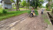 M Fadli (54) warga Gampong Paya Dua, Kecamatan Makmur melintas jalan penghubung kecamatan dengan kondisi becek, berlumpur dan licin pasca diguyur hujan, Senin (11/5).