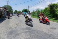 Pengendara melintasi jalan elak yang berlubang di kawasan Geulanggang Teungoh, Kecamatan Kota Juang membahayakan pelintas, Rabu (13/5) siang.