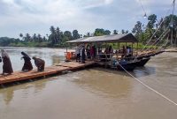 Warga melintas di jembatan apung Kepala Hiu yang selesai, saat di peusijuk menandai berfungsinya layanan penyeberangan dari Gampong Pante Lhong, Kecamatan Peusangan ke Pante Kumbang Peusangan Siblah Krueng, Rabu (7/5) pagi.