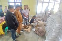 Petugas memasukkan minyak goreng kemasan ke kantung plastik untuk dibagikan kepada penerima, di Balai Desa Kantor Camat Peusangan, Selasa (9/6) pagi.