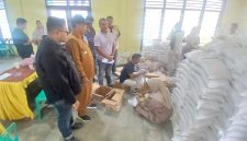 Petugas memasukkan minyak goreng kemasan ke kantung plastik untuk dibagikan kepada penerima, di Balai Desa Kantor Camat Peusangan, Selasa (9/6) pagi.
