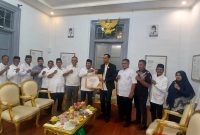 Bupati Bireuen, Ir H Mukhlis, ST menerima penghargaan yang diserahkan oleh Ketua Komisi Informasi Aceh (KIA) Provinsi Aceh, Junaidi, di Pendopo Bupati, Jumat (12/6) sore.