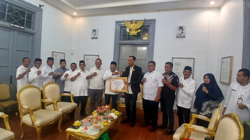 Bupati Bireuen, Ir H Mukhlis, ST menerima penghargaan yang diserahkan oleh Ketua Komisi Informasi Aceh (KIA) Provinsi Aceh, Junaidi, di Pendopo Bupati, Jumat (12/6) sore.