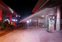 Petugas pemadam pos induk Kota Bireuen mendinginkan dispencer SPBU Reulet terbakar saat mengisi BBM Pertalite ke satu unit sepeda motor, Jumat (19/6) malam.