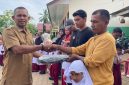 Kepala SDN 19 Juli, Ismadi S.Pd menyerahkan hadiah tas kepada siswa baru sekolah itu, Senin (13/7)