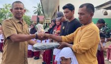 Kepala SDN 19 Juli, Ismadi S.Pd menyerahkan hadiah tas kepada siswa baru sekolah itu, Senin (13/7)