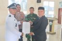 Camat Kota Juang, Saifuddin S.KM M.Kes menyerahkan SK kepada Keuchik Geulanggang Baro, Syafruddin usai prosesi pelantikan di aula Kantor Camat, Sabtu (15/08)