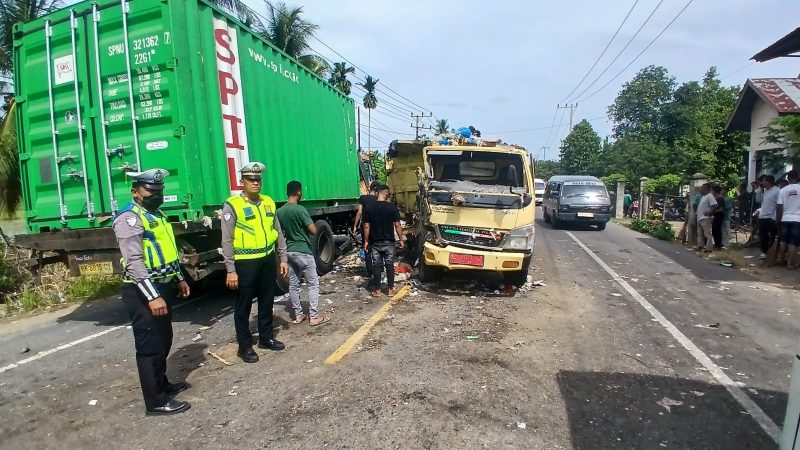 Kasatlantas Polres Bireuen, AKP Irwansyah Nasution dan anggota mengamankan lokasi tabrakan truk sampah dan truk muatan box container di jalan Banda Aceh-Medan Gampong Ceurucok, Kecamatan Simpang Mamplam, Minggu (9/8) pagi.