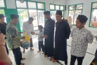 Keuchik Geulanggang Baro, Safruddin dan Imum Gampong Tgk Fakurrazi menyerahkan santunan kepada anak yatim, di Meunasah, Minggu (4/10) pagi.