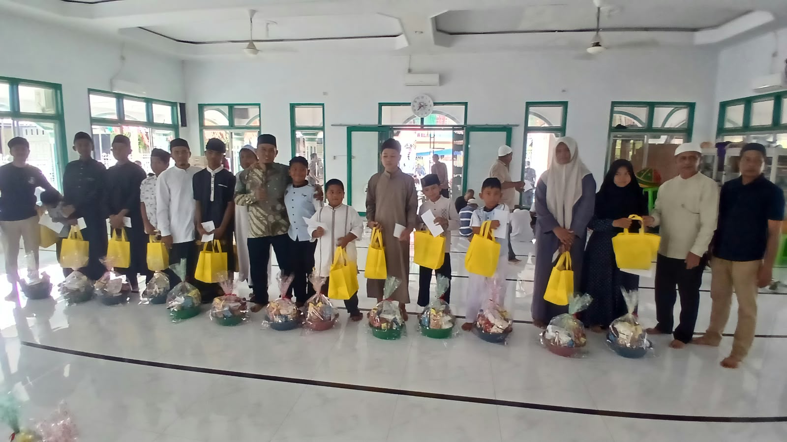Keuchik Geulanggang Baro, Safruddin dan Imum Gampong Tgk Fakurrazi menyerahkan santunan kepada anak yatim, di Meunasah, Minggu (4/10) pagi.