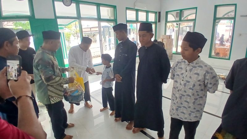Keuchik Geulanggang Baro, Safruddin dan Imum Gampong Tgk Fakurrazi menyerahkan santunan kepada anak yatim, di Meunasah, Minggu (4/10) pagi.