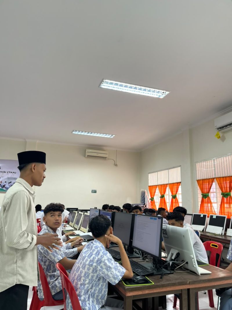 Hasbawi, mahasiswa Ekonomi Syariah UNIKI Bireuen menjadi pengawas simulasi TKA di MAN Jeunieb, Jumat (30/10).