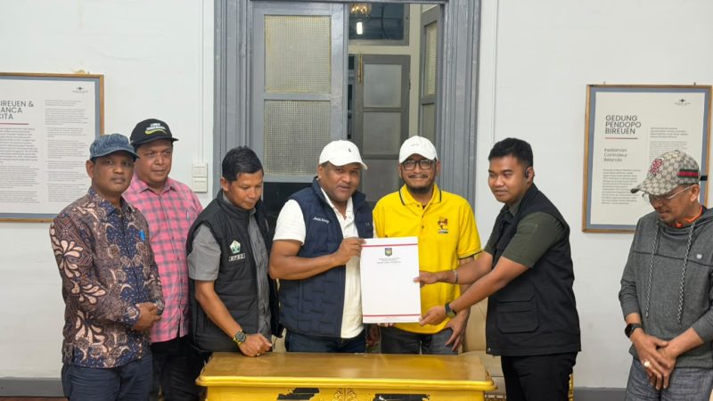 Bupati Bireuen, Ir Mukhlis ST dan Wakil Bupati, Ir H Razuardi MT memperlihatkan berita acara serahterima lima Escavator, Kamis (15/10)