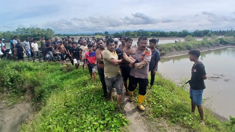 Kapolsek Gandapura, Iptu Jusman dan warga membawa jenazah korban tenggelam ke darat, usai ditemukan, di alur sungai Gampong Mon Jambe, Kecamatan Gandapura, Minggu (25/10) siang.